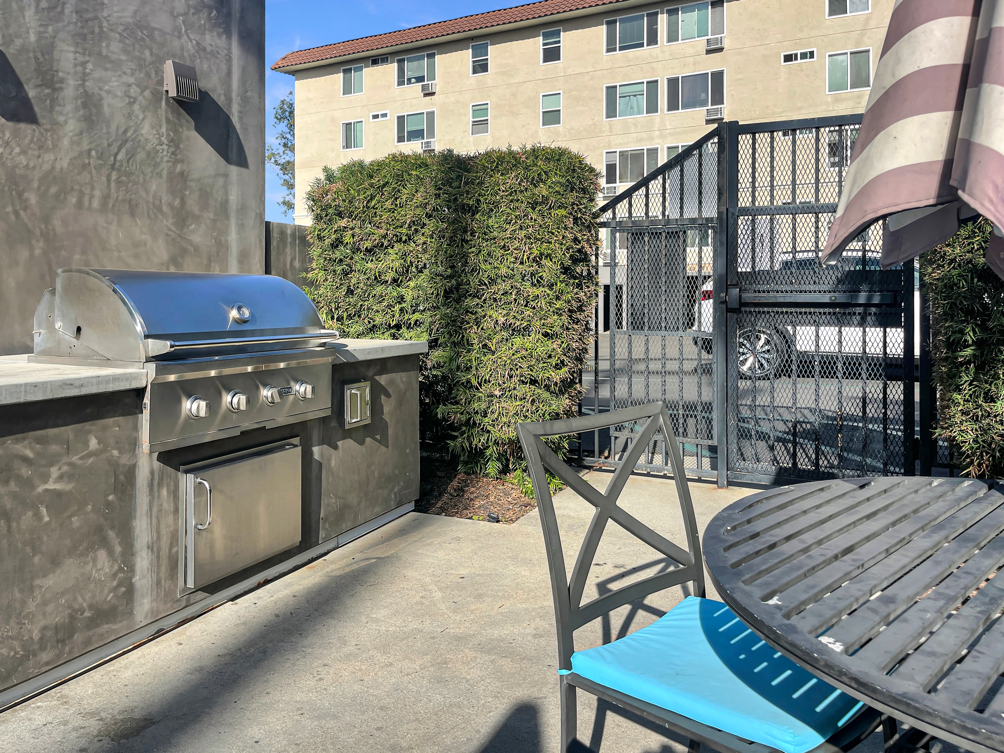 Outdoor BBQ station with stainless grill and patio seating at Asana at North Park