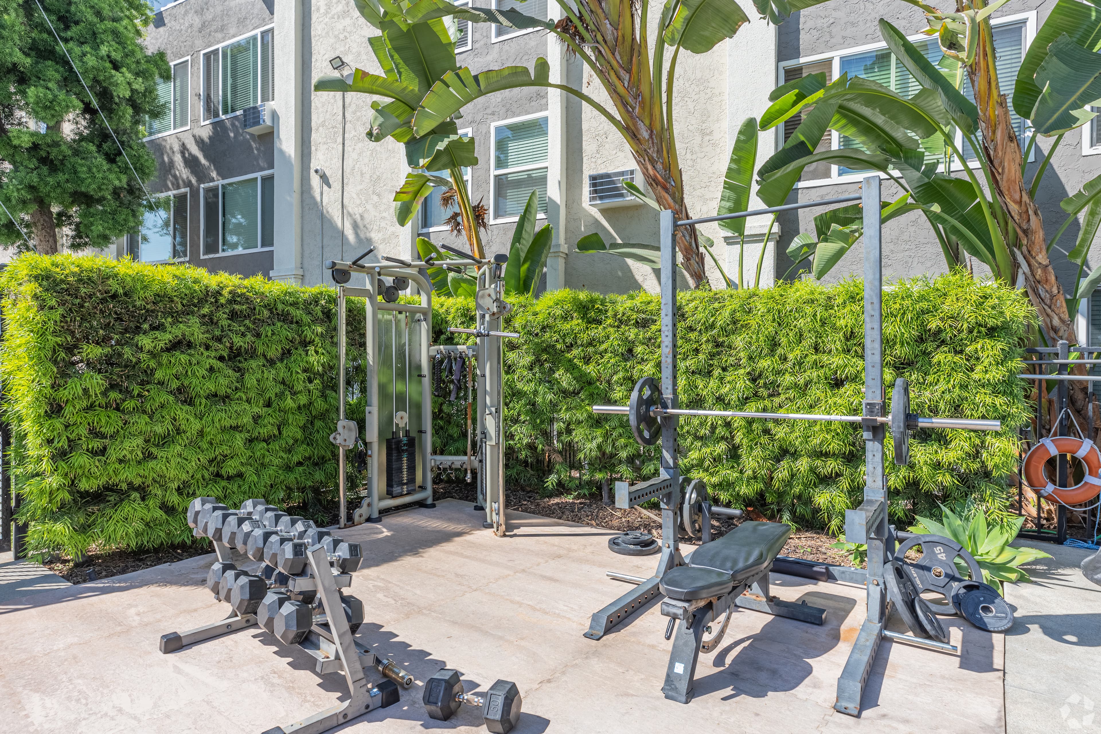 Outdoor fitness area with weights and equipment next to Asana at North Park building